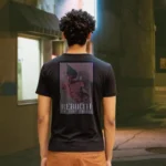 A male model with his back turned wearing a black Dark Fantasy shirt featuring a grotesque creature, seemingly being born, wriggling from its attachment