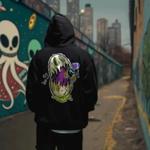 A male model with his back turned wearing a black Easy Days hoodie featuring a monsterfied balut egg graphic.
