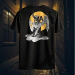 Back view of black Manifesto shirt displaying a winged horned woman sat down, holding a dagger with an evil grin rear graphic placement