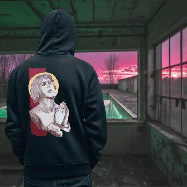 A male model with his back turned wearing a black Manifesto hoodie featuring a man who seems like a statue, hands in a praying position, eyes staring at the skies above