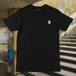 Front view of black tshirt featuring the Flip Me skateboard and beach graphic.