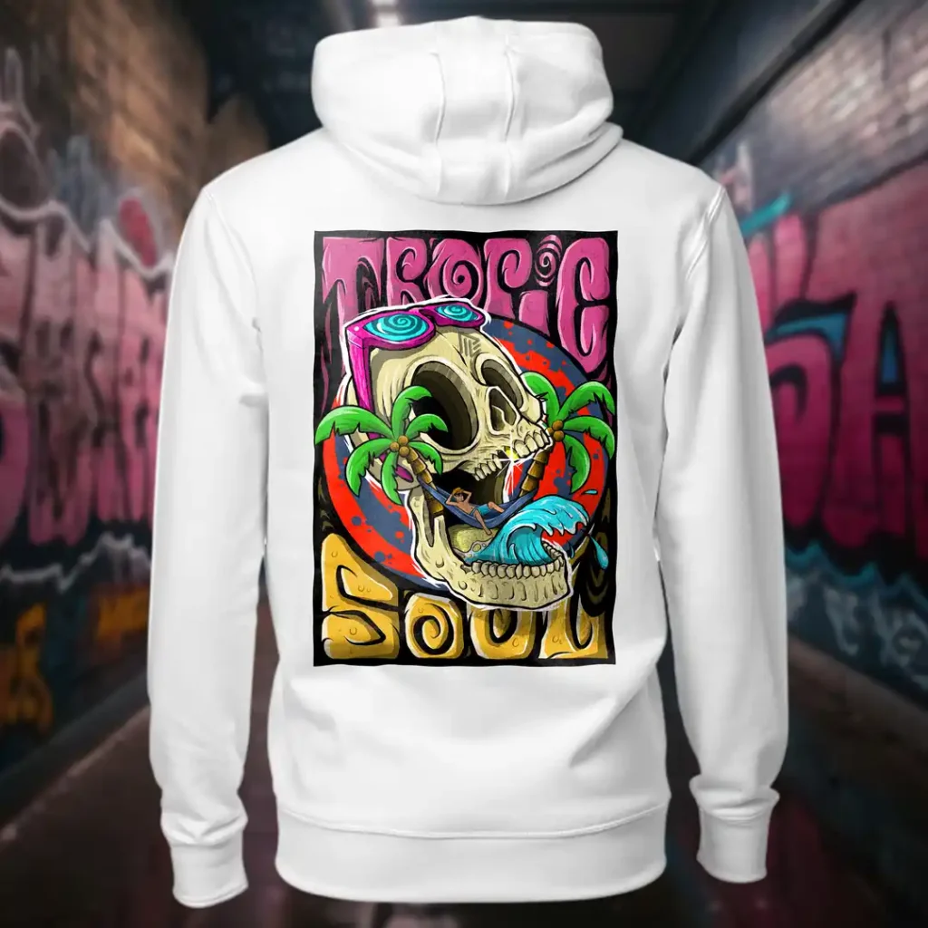 Back view of white Tropic Soul hoodie displaying a man relaxing on a hammock tied to the Skull Island's palm trees next to a giant wave rear graphic placement and hood detail.