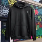 Front view of black pullover hoodie featuring a man relaxing on a hammock tied to the Skull Island's palm trees next to a giant wave graphic.