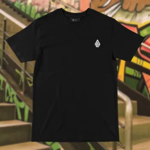 Front view of black tshirt featuring a man relaxing on a hammock tied to the Skull Island's palm trees next to a giant wave graphic.