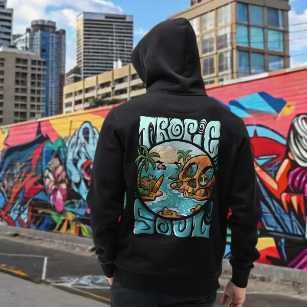 A male model with his back turned wearing a black tropic soul hoodie featuring the Secret Skull, treasures, animals and waves graphic.