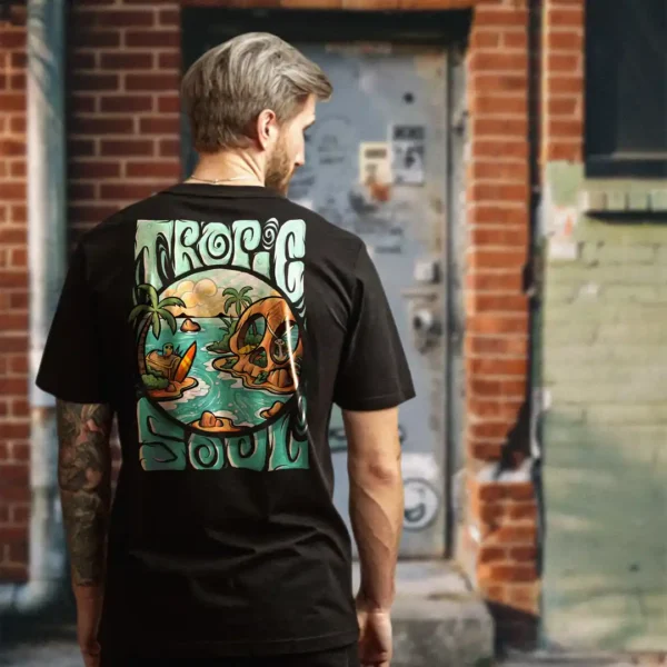 A male model with his back turned wearing a black tropic soul tshirt featuring the Secret Skull, treasures, animals and waves graphic.