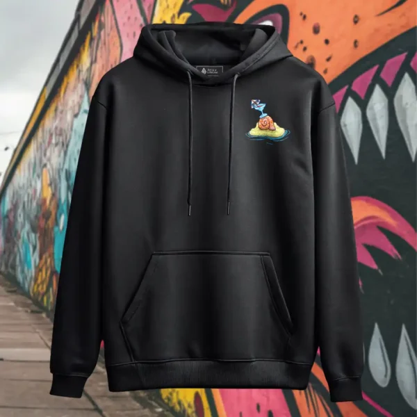 Front view of black pullover hoodie featuring a roasted pig skewered by a bamboo stick, lying underneath an umbrella taking cover from the sun.