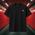 Front view of black shirt featuring a red winged creature of dark, visibly hanged by ropes, opening its stomach with its unseen face